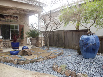 Modern Japanese rock garden with raked decomposed granite and basalt boulders