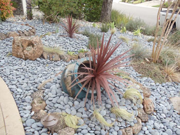 Modern Japanese rock garden with raked decomposed granite and basalt boulders