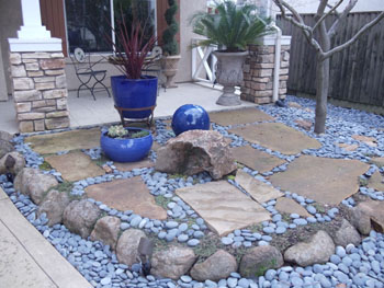 Modern Japanese rock garden with raked decomposed granite and basalt boulders