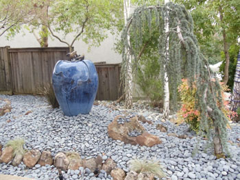 Modern Japanese rock garden with raked decomposed granite and basalt boulders