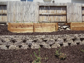 Engineered interlocking concrete block retaining wall for hillside erosion control