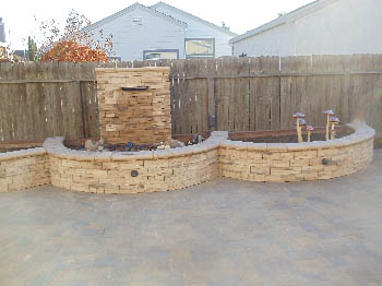 Natural stone pondless waterfall with LED lighting and aquatic plants