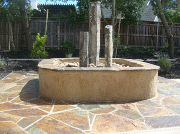 Natural stone pondless waterfall with LED lighting and aquatic plants